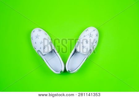 Women Or Teenage Fashion, White Slipons, Stylish Shoes On Green Background. Beauty And Fashion Conce