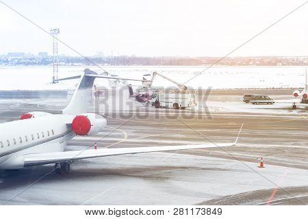 Deicing Of Private Jet Before Departure At Airport In Winter. Aircraft Protection Against Freezing .