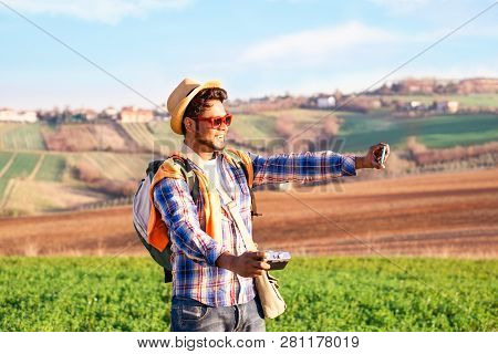 Happy Indian Hiker Taking Selfie Using Phone And Old Camera On Fields Background At Sunset Lights - 