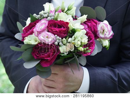 Wedding Bouquet In Hands At The Groom.