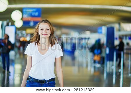 Young Woman In International Airport Walking With Luggage, Ready For Her Flight