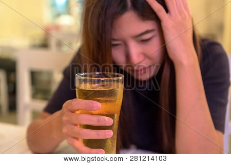 Asian Young Woman In Lonely And Depressed Action And Holding Glass Of Beer In Pub And Restaurant Wit