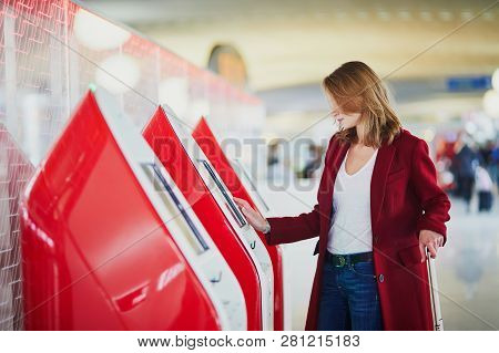 Young Woman In International Airport Doing Self Check-in