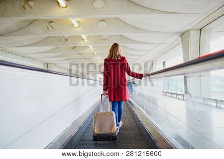 Young Woman In International Airport With Luggage On Travelator