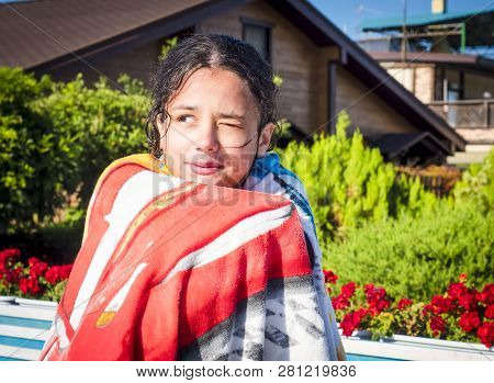 A Young Girl Is Warming Up Just After A Swim In A Pool.