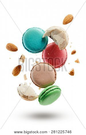 French macarons with almonds crushed into pieces. Colorful macaroons on white background. 