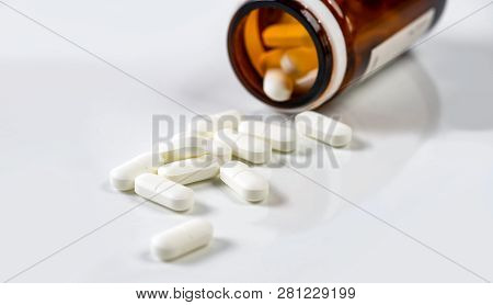 White Medicine Capsules Scattered Out Of Vial