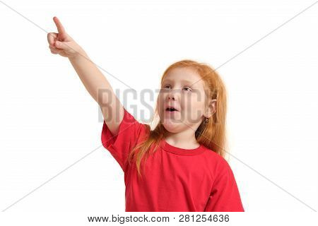Education, School And Imaginary Screen Concept - Cute Little Girl Pointing In The Air Or Imaginary S