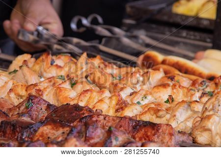 A Man Fries A Barbecue Of Pork Meat And A Grill On The Back Of The Chicken Meat