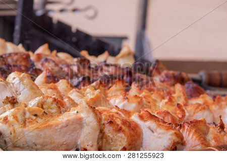 A Man Fries A Barbecue Of Pork Meat And A Grill On The Back Of The Chicken Meat