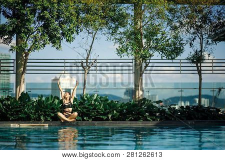 Sexy Slim Caucasian Brunette Stretch Oneself Between Green Bushes And Trees On Edge Of Swimming Pool