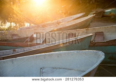 Closeup Of Old Shabby Wooden Fishing Colorful Boats And Boat Bow During A Sunset With Sun Rays, Sele