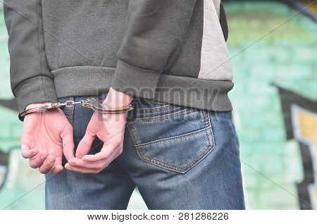 Back View Of The Arrested Bandit From The Ghetto Against The Gra