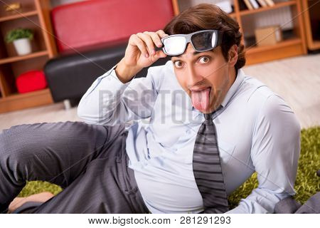 Young employee with virtual glasses during break in the office 