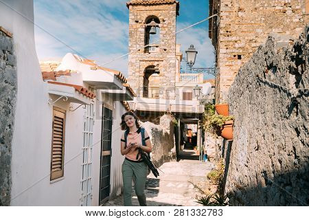 Terracina, Italy. Young Caucasian Woman Tourist Walking At Street Near Bell Tower Of Church Of San G
