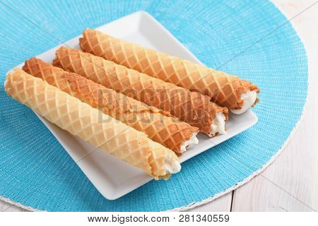 Gaufres de Montcuq, rolled wafers with cream filling  on a white dish