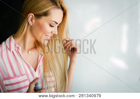 Woman Spraying Hairspray On Beautiful Long Hair