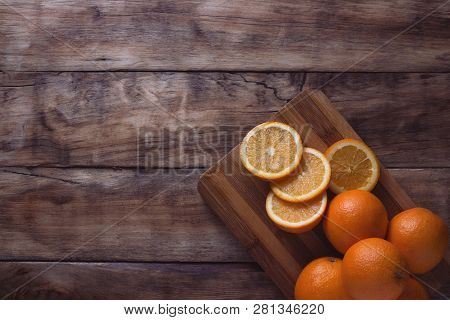 Cut Orange, Slices Of Apelsin On The Wooden Board. Dark Background. Flat Lay, Top View