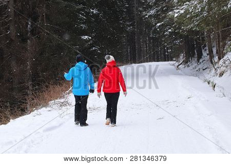 Group Of People Enjoying A Snowshoeing On A Trail In Winter. A Group Of People Enjoying Snowshoeing 
