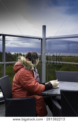 Dark Sky Before The Storm, Women Drink Coffee Or Tea On Terrace And See On Sea