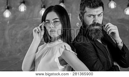 Man With Beard And Teacher In Eyeglasses Stand Back To Back, Chalkboard On Background. Lady And Hips