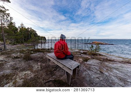 Man In Red Jacket Sitting On A Bench