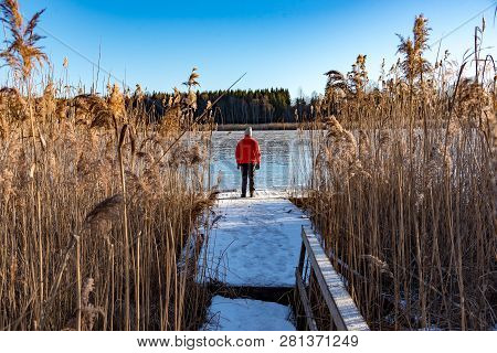 Man Standing At A Jetty Between Reed