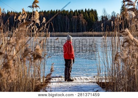 Man Standing At A Jetty Between Reed