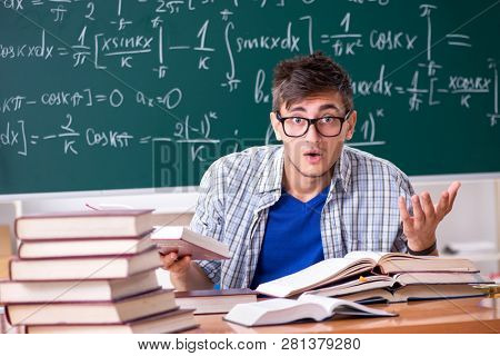 Young male student studying math at school