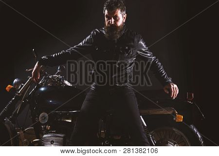 Macho, Brutal Biker In Leather Jacket Stand Near Motorcycle At Night Time, Copy Space. Man With Bear