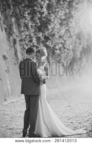 Beautiful Young Lovely Wedding Couple Of Blond Woman In Long White Dress With Calla Flower Bunch And