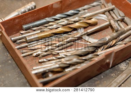Working Tools. Drill. Drilling Tool. Instrumen Lies In The Garage In The Cup.