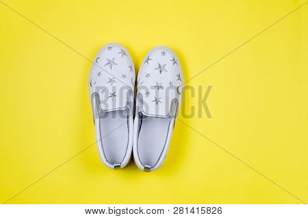 Women Or Teenage Fashion, White Slipons, Stylish Shoes On Yellow Background. Beauty And Fashion Conc
