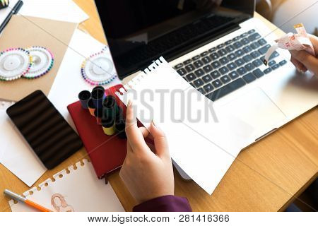 Professional Fashion Designer Working And Drawing Sketches On The Table With Computer Tablet And Col