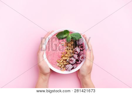 Womans Hands Holding Raspberries Smoothie Bowl With Mint Leaf On Pink Background. Top View, Copy Spa