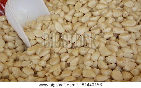 Many White Garlic Bulbs For Sale With Serving Spoon
