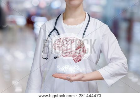 A Closeup Of A Mental Health Brain And Cogwheel Mechanism Modal Hanging Above A Hand Of Young Doctor