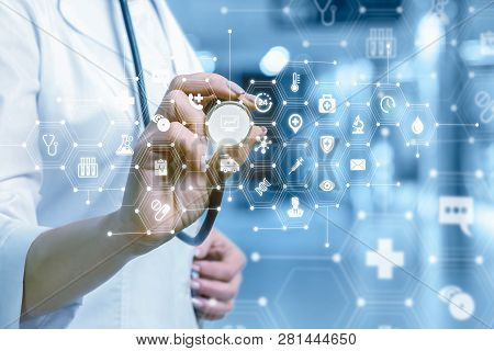 A Closeup Of Doctor Standing And Touching A Medical Icons Combs System With Symbols With Her Stethos