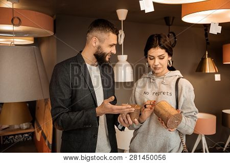 Curious Couple Carrying Brown Candles And Discussing Their Functionality