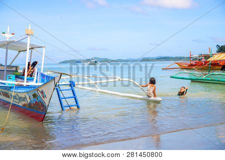 Port Barton, Philippines - 23 Nov 2018: Children Playing In Sea Water By Fishing Boat. Filipino Kids