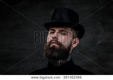 Close-up Portrait Of An Old-fashioned Bearded Man With Tattoos On His Neck Wearing A Top Hat, Isolat