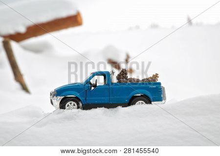 Moscow. January 2019. Blue Toy Pickup Truck Ford F350 In Sawmill. Carrying Fir Cones. Sawdust In Sno
