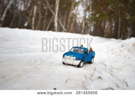 Moscow. December 2018. Blue Toy Pickup Truck Ford F350 In Snow Forest. Carrying Fir Cones. Winter Ro