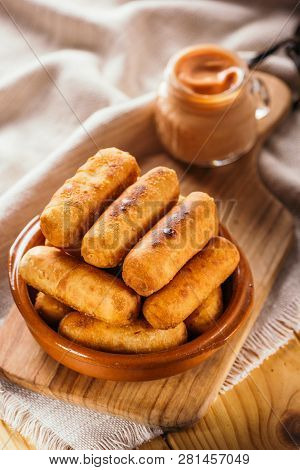 Cheese Fingers, Typical Venezuelan Appetizer Called Tequeños Accompanied With A Pink Sauce On A Wood