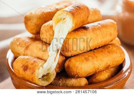 Cheese Fingers, Typical Venezuelan Appetizer Called Tequeños Accompanied With A Pink Sauce On A Wood