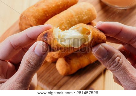 Woman's Hands Holding An Appetizing And Delicious Tequeño Typical Snack Of Venezuelan Food