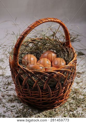 Six Eggs Lying On A Hay In A Basket. Easter Or Village Theme.