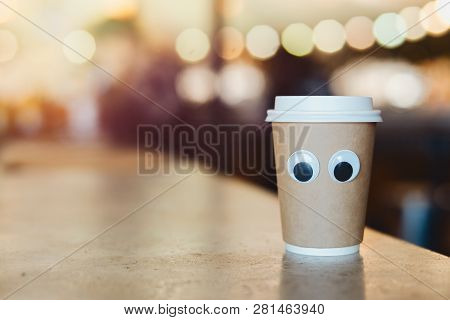 Coffee Takeaway Cup With Cartoon Eyes In Cafe. Concept Of Hospitable Cafe