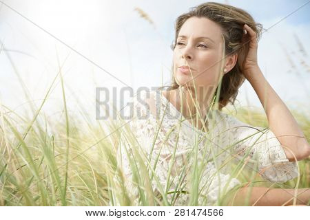 Portrait of attractive woman sitting in wildgrass