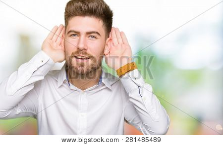 Young handsome business man Trying to hear both hands on ear gesture, curious for gossip. Hearing problem, deaf
